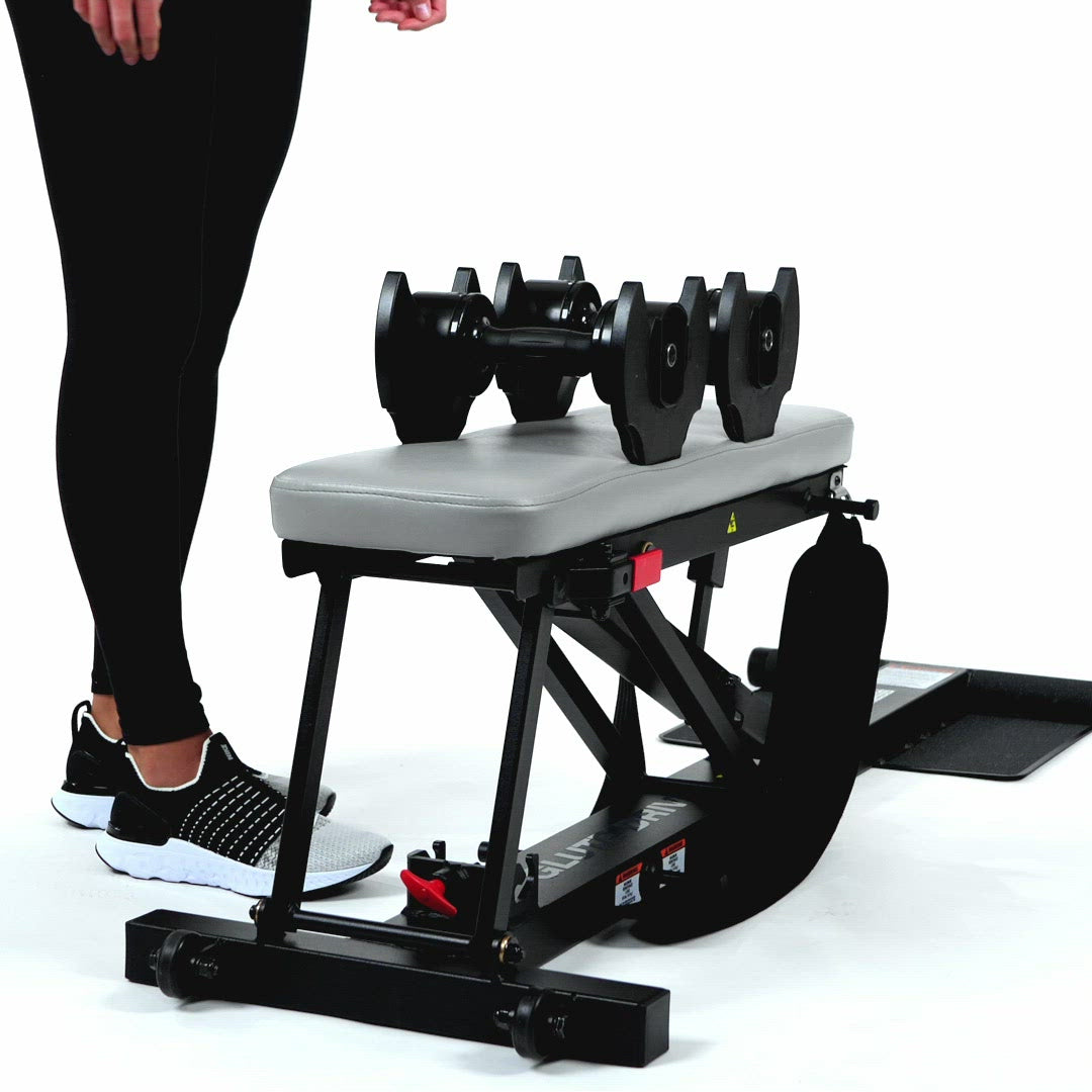 Woman Standing Above Adjustable Dumbbells & Glute Drive Plus Combo Pack